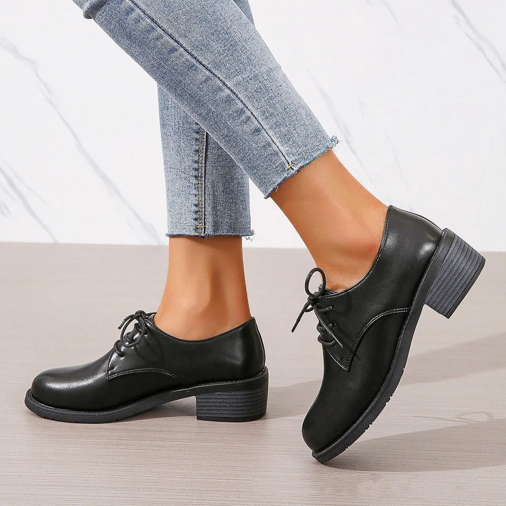 Black women's low-top work shoes with a thick chunky mid-heel and rubber sole.
