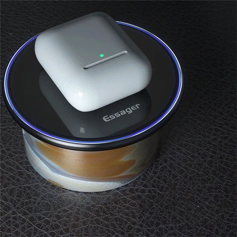 Black wireless charging pad on desk with phone charging, showing blue LED indicator light
