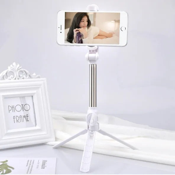 Bluetooth selfie stick tripod with remote control extended, showing adjustable phone clip in black colour.