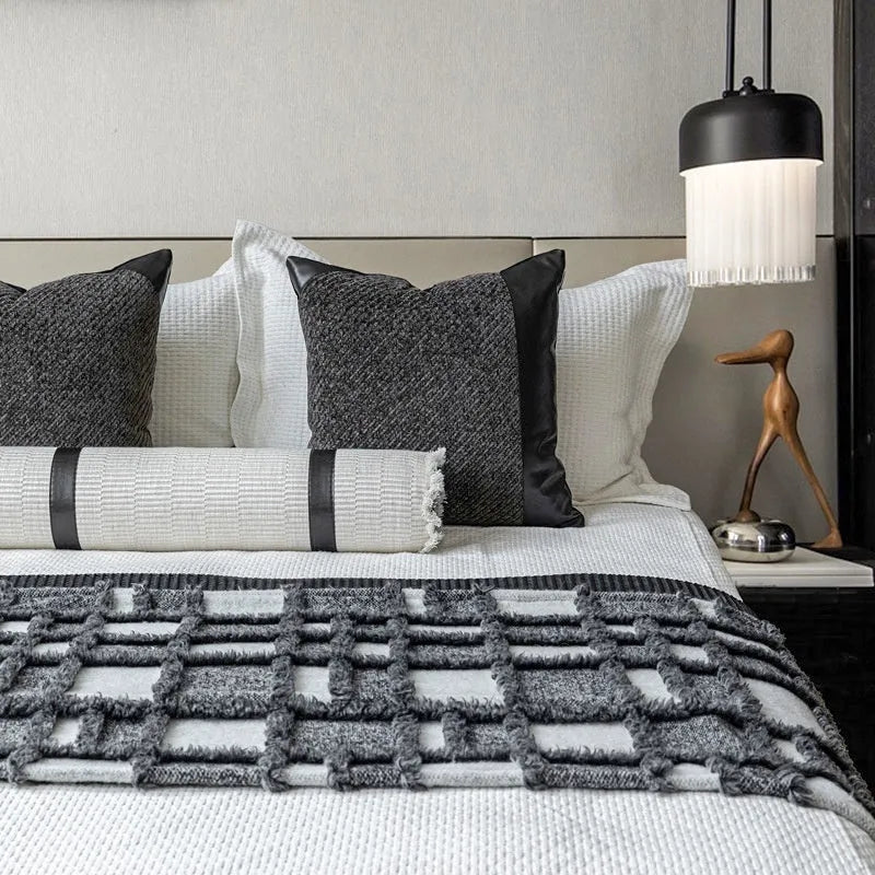 Modern grey and white plaid bed runner blanket set with a pillowcase and leather round pillow on a 1.5m bed.