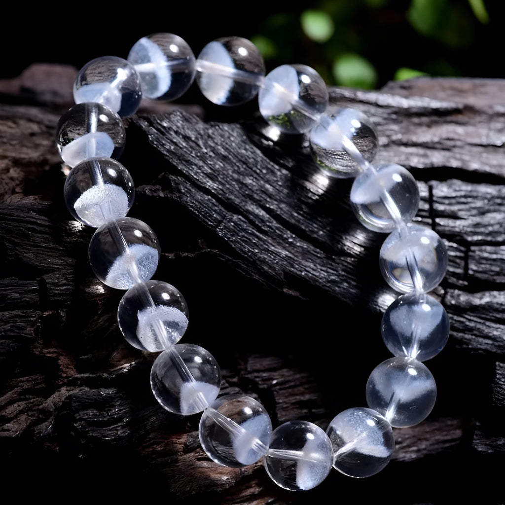 Women's white crystal pyramid bead bracelet with a Ruyi charm on a wrist.