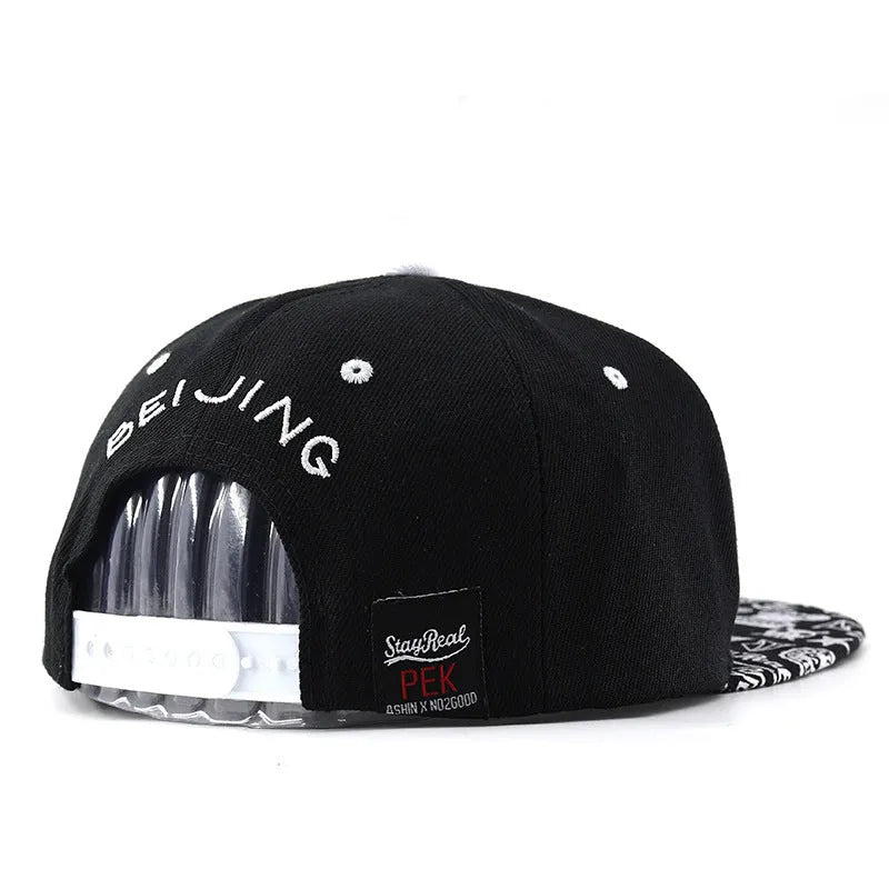 Black cotton baseball hat with white embroidered letters on the front, showing the dome crown shape.
