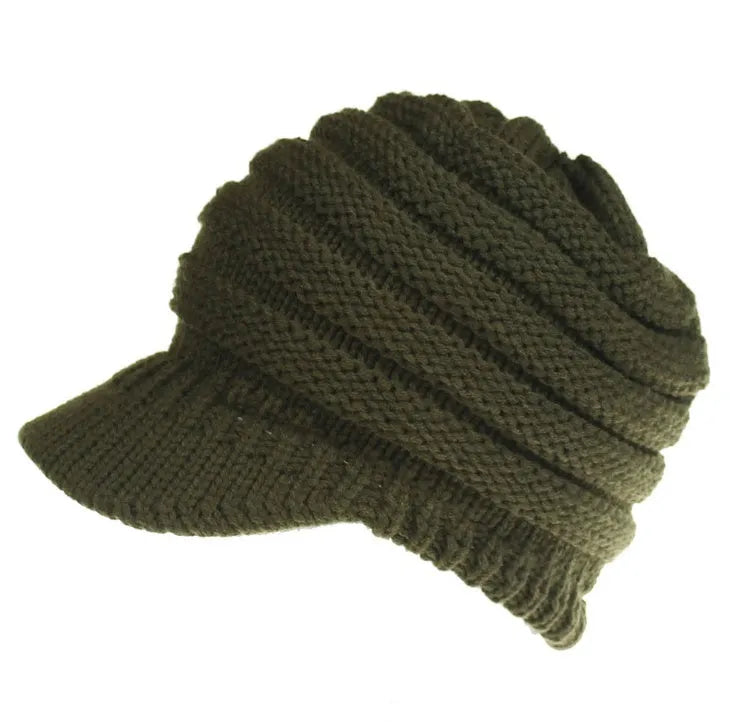 Woman wearing a thick knitted beanie with a ponytail threaded through the hole in the crown.