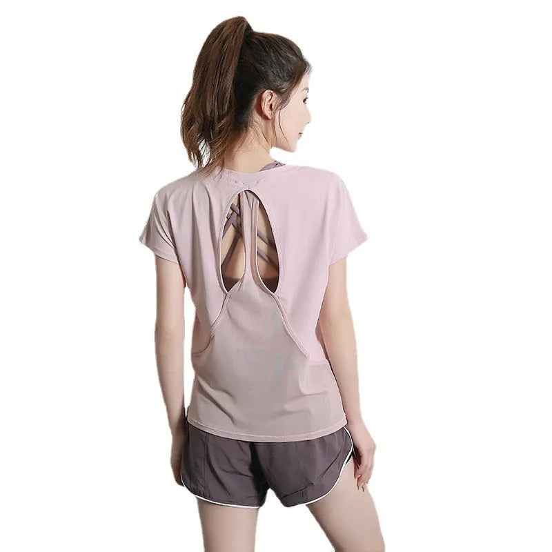 Women's short sleeve polyester sports t-shirt for yoga and running in pink, on a hanger.