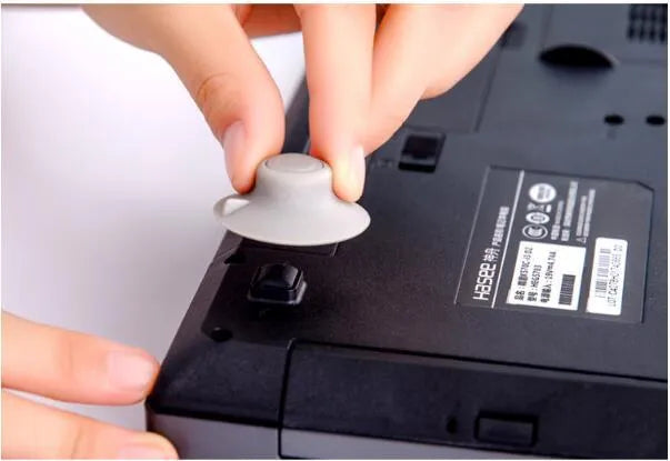 Grey plastic laptop cooling pads, two large and two small, placed under a mini notebook.