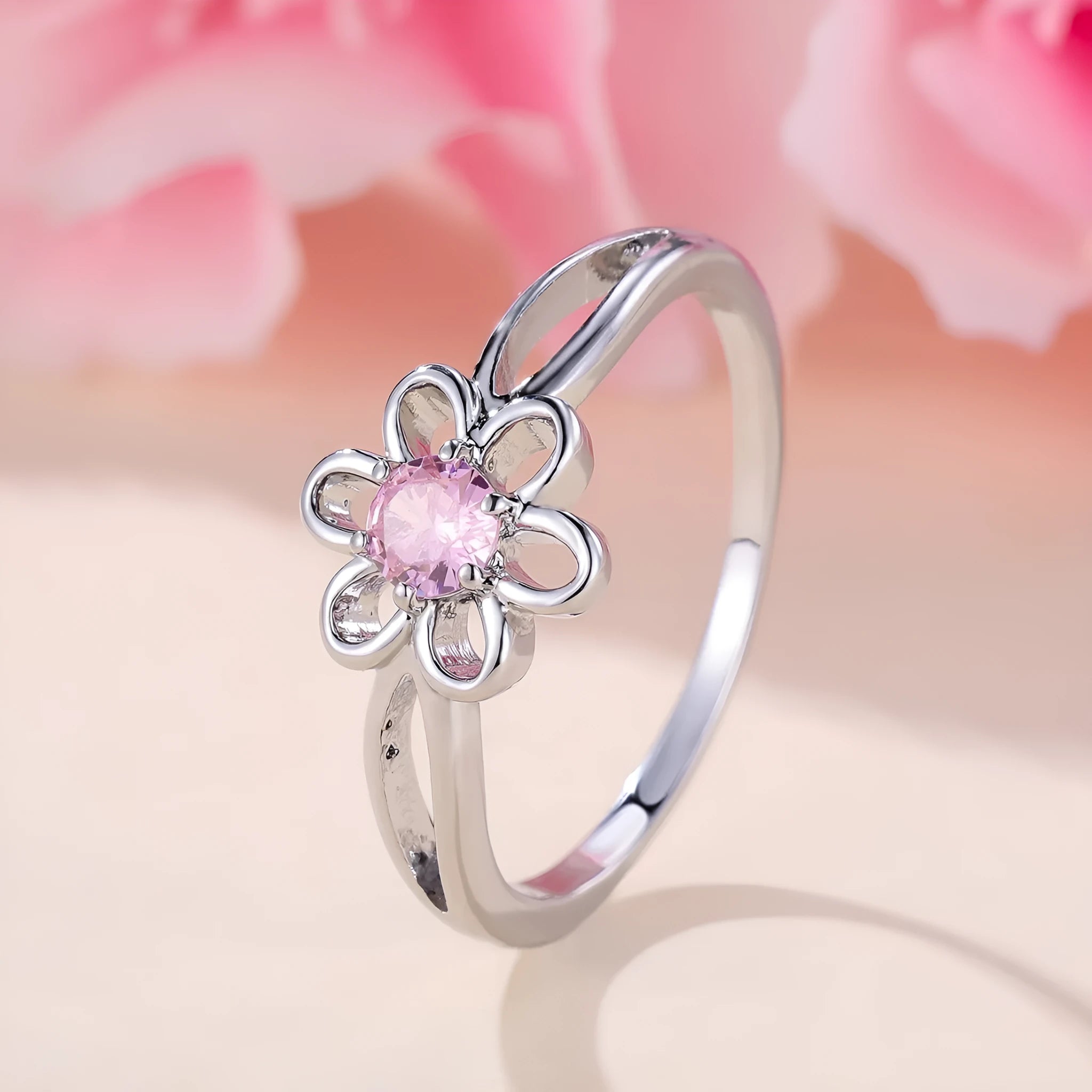 Close-up of a women's hollowed flower ring with a platinum pink diamond electroplated finish.