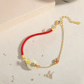 Women's 925 silver bracelet with gold electroplated peace buckle, koi fish charm, and adjustable red rope.