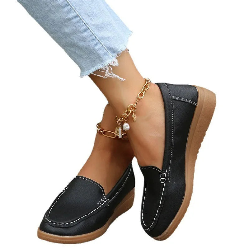 Women's flat loafer in PU leather with car suture stitching and a round toe.
