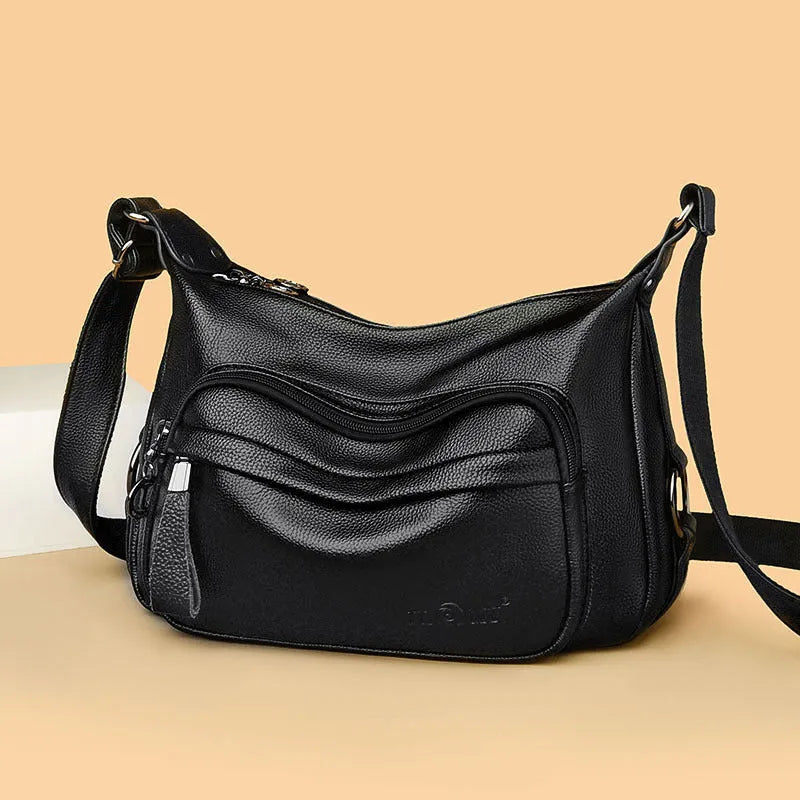 Large black women's shoulder bag with multiple compartments and luggage-inspired styling