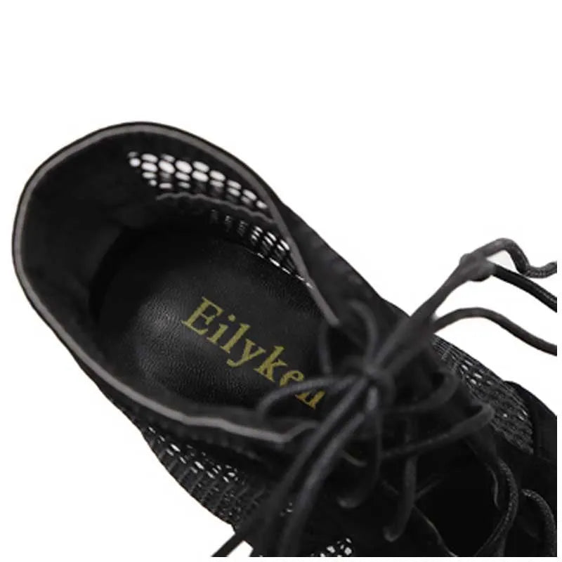 Black suede women's lace-up high heel shoes with a high heel on a plain background.