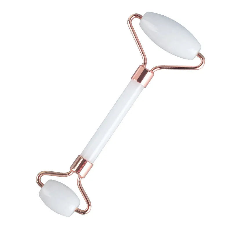 White jade double-headed facial roller and gua sha scraping board set on a neutral background.