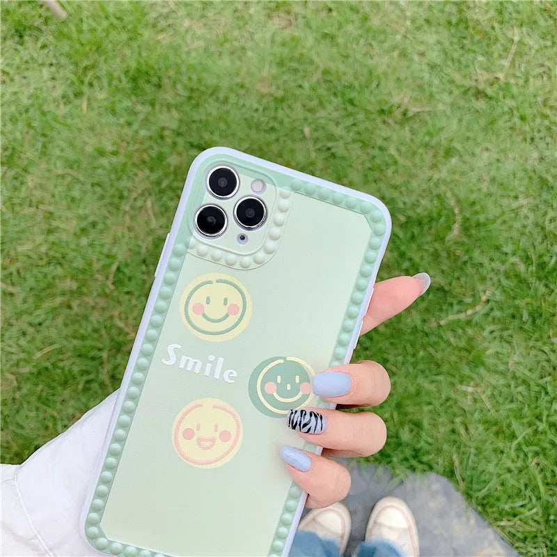 Green TPU iPhone case with geometric smiley face polka dot patterns on a phone