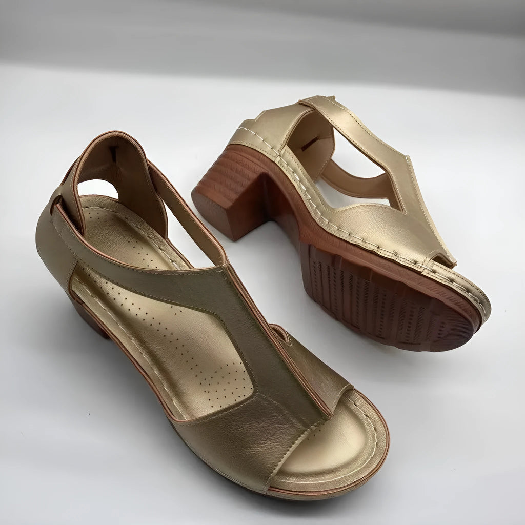 Women's white peep toe wedge sandals with Roman-style buckle ankle straps on a low heel.