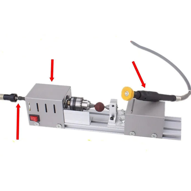 Mini silver metal woodworking lathe with carving knives on wooden surface