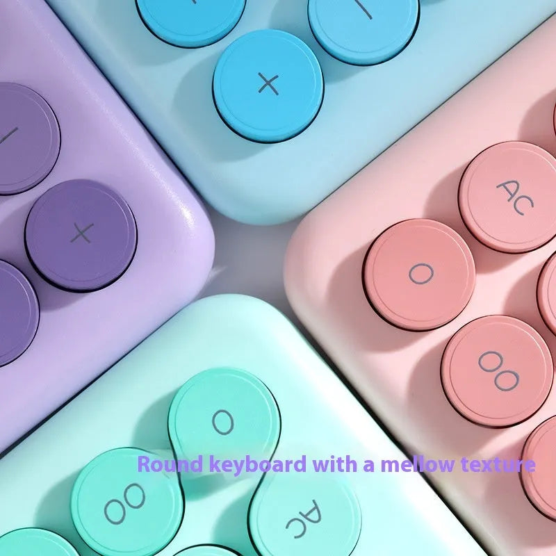 Gradient colour desk calculator in violet, cherry blossom pink, blue, and mint green finishes on a desk.
