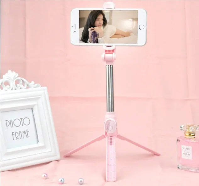 Bluetooth selfie stick tripod with remote control extended, showing adjustable phone clip in black colour.