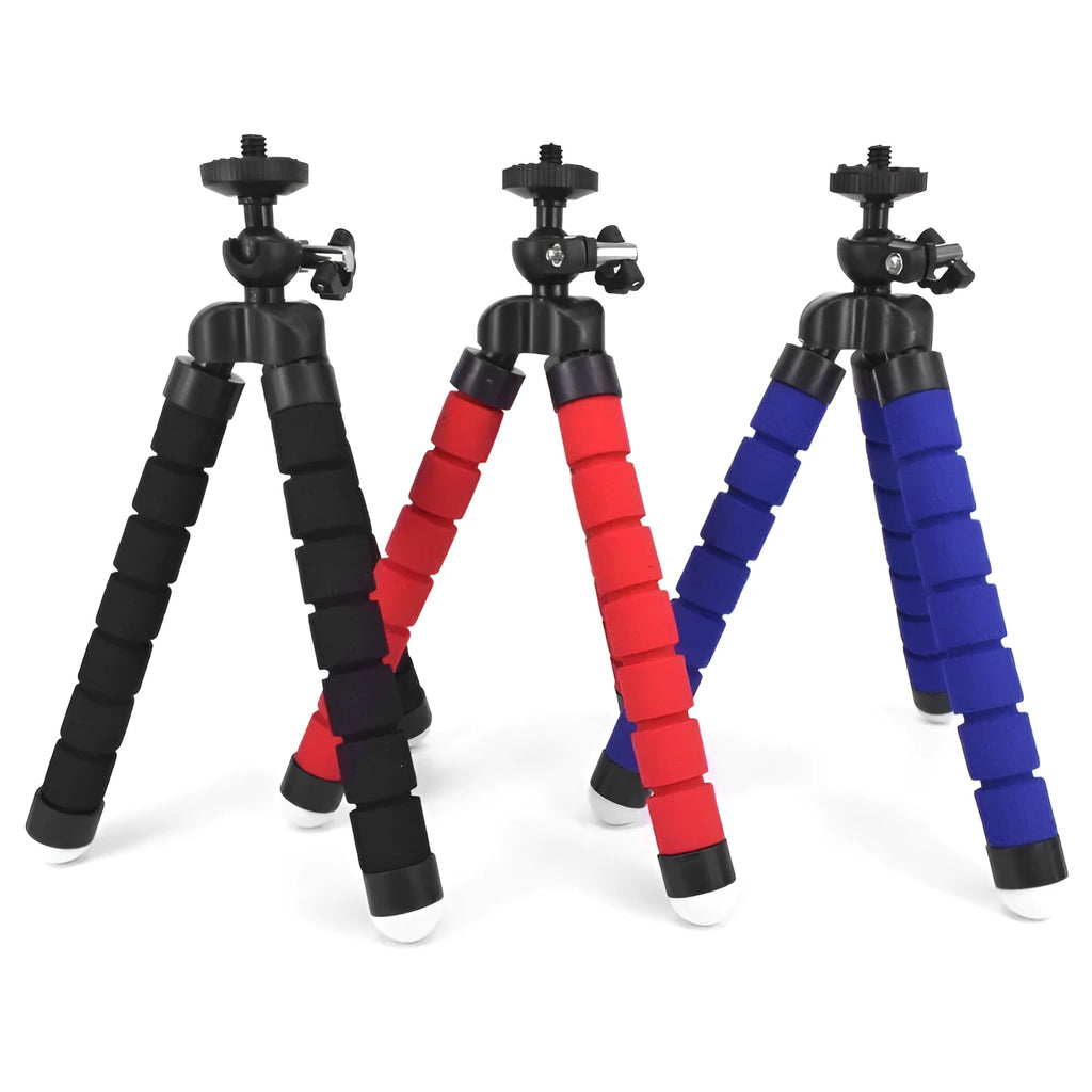 Black flexible octopus leg tripod standing on a table next to a smartphone
