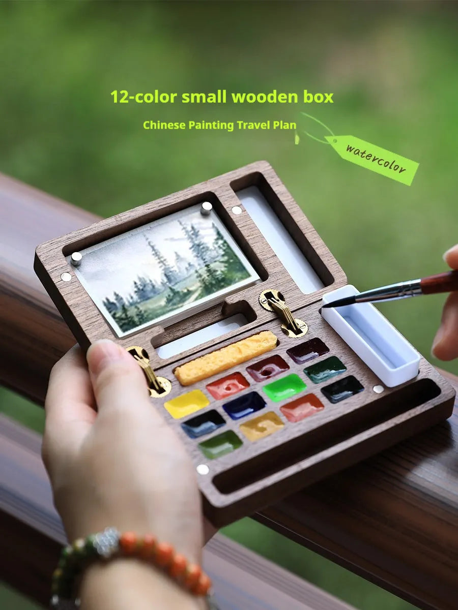 Mini walnut wooden watercolour paint box open to show pigment suit inside