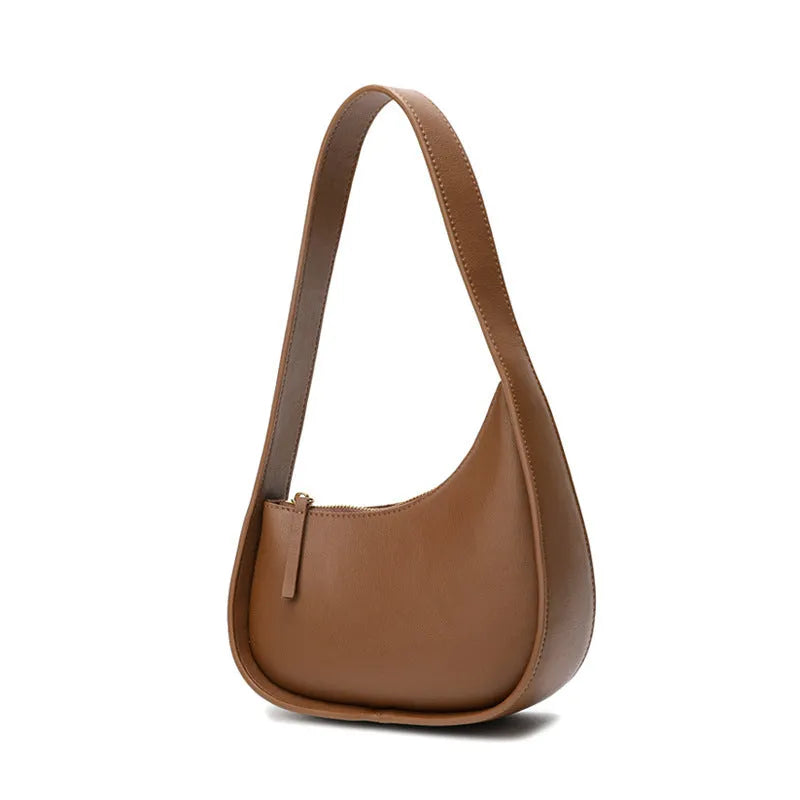 Small half moon shaped women's leather shoulder bag with a wide strap and soft handle.