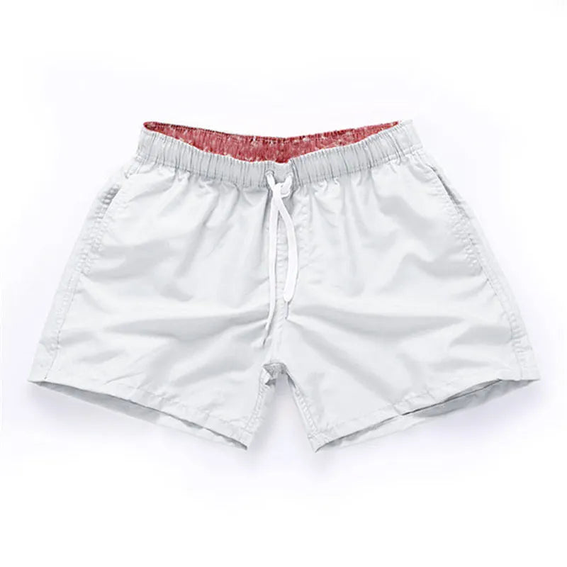 Men's straight-leg polyester beach shorts on a hanger, showing the classic fit and available in multiple solid colours.