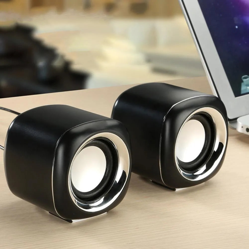 Pair of compact black wired computer speakers with 3.5mm plug showing 7.2cm cube dimensions