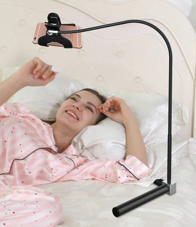 Black mobile phone bed bracket mounted beside bed frame holding smartphone