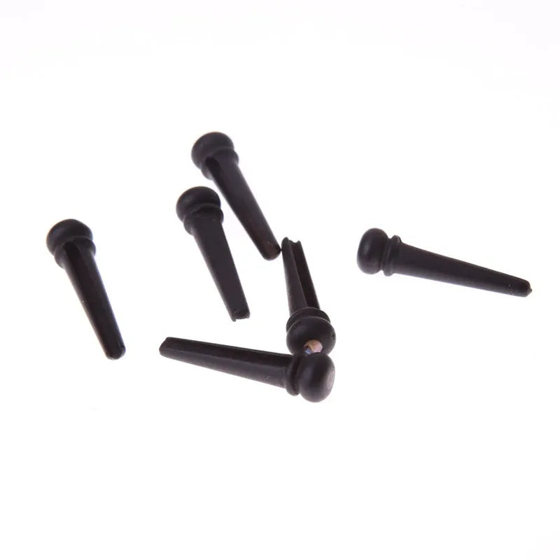Set of six matt black ebony guitar bridge pins or string nails for acoustic guitar.