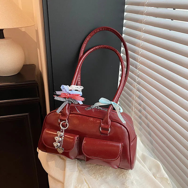 Pillow-shaped PU leather women's handbag in black with ribbon pendant and double shoulder strap