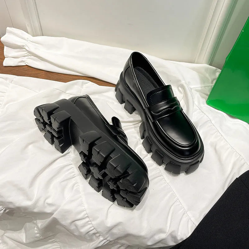 A pair of British style wide fit loafers with a muffin heel, shown in patent leather and matte colour options.