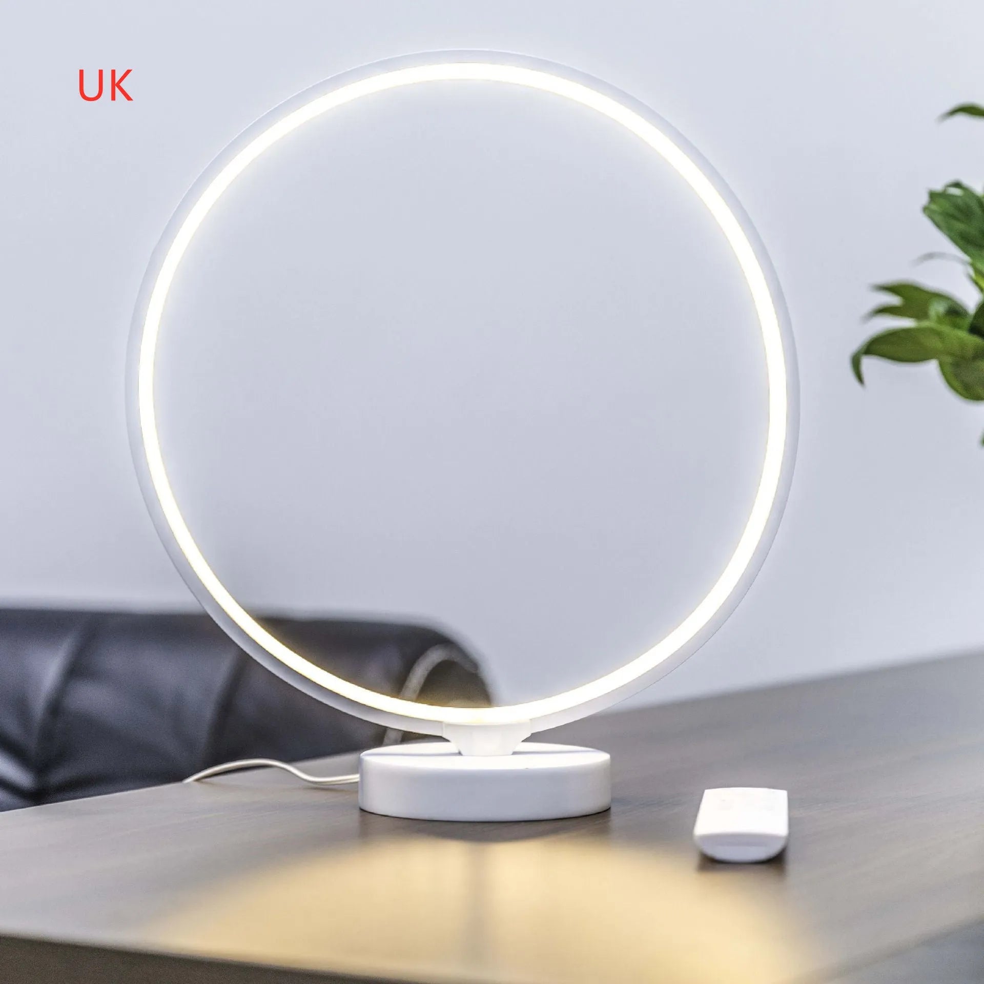White Full Moon mood lamp on a table with remote control, showing soft ambient glow.