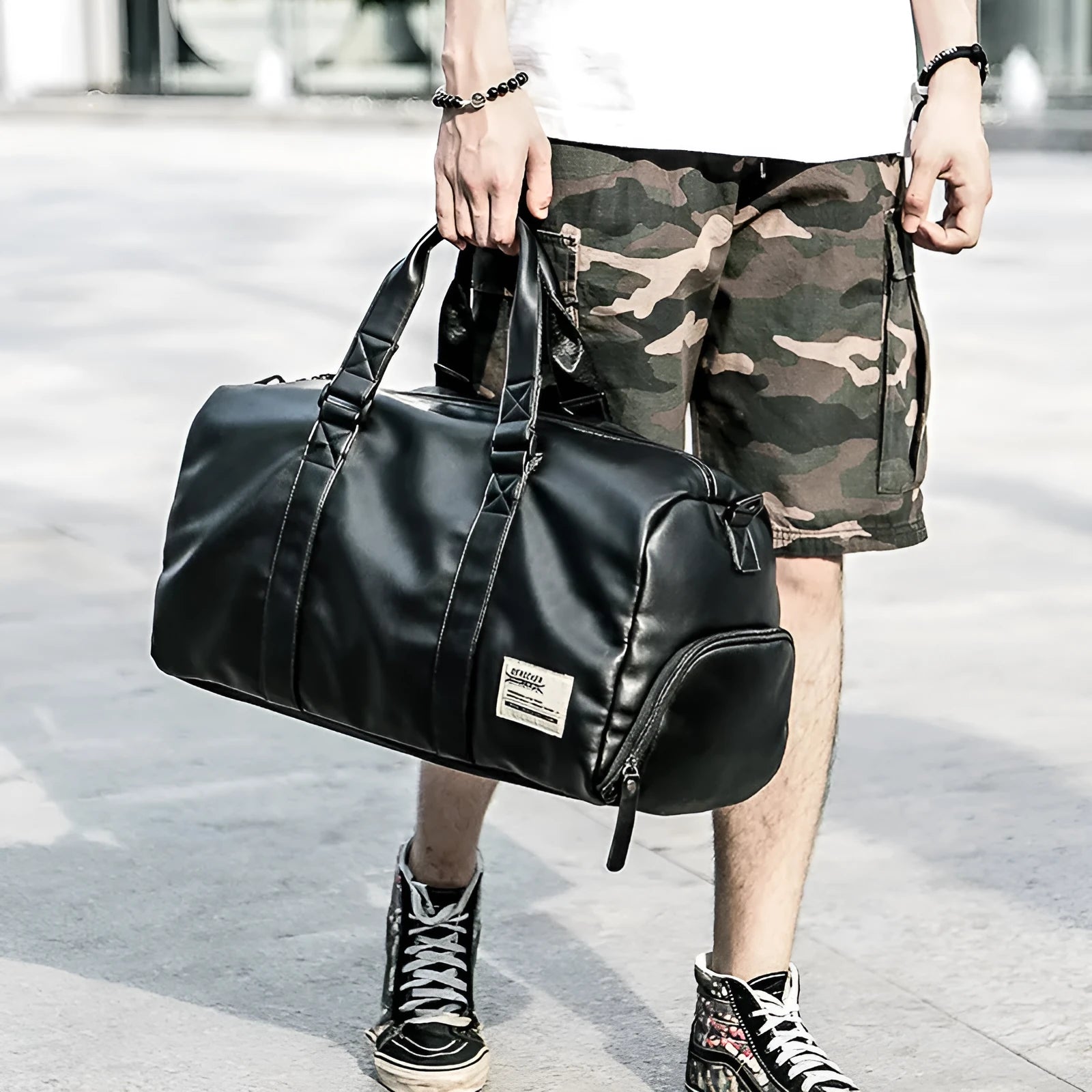 Large black PU leather sports training bag showing multiple zippered pockets and a single shoulder strap.