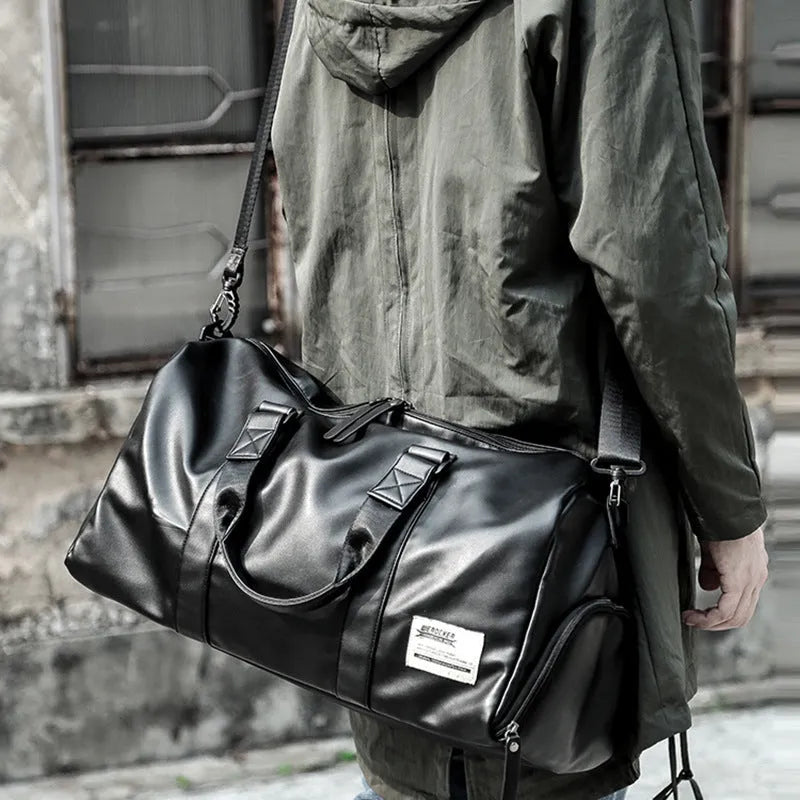 Large black PU leather sports training bag showing multiple zippered pockets and a single shoulder strap.