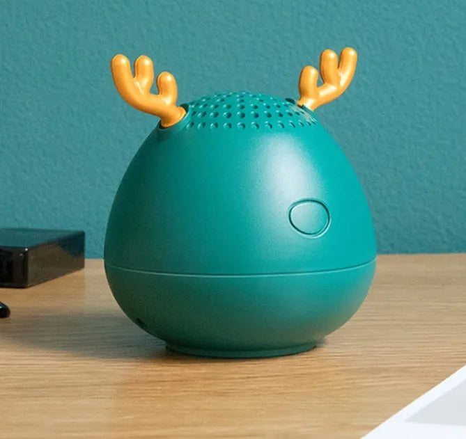 Small green Bluetooth speaker on a table showing its compact size.