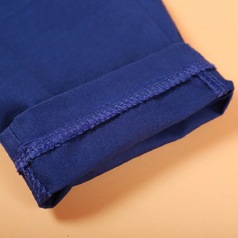 Blue boys' three-piece suit set with vest, tie, and trousers on a hanger.