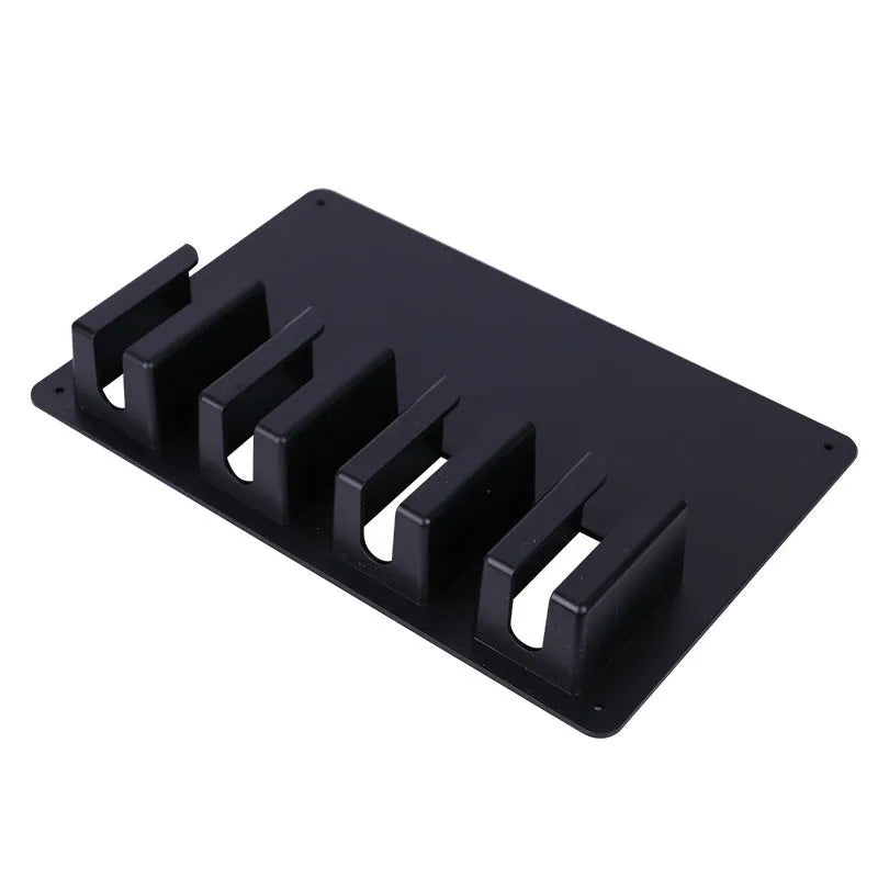 Black plastic wall-mounted storage rack holding four hair clippers
