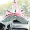 Angel wings gypsum car perfume pendant with black ribbon and white wings hanging from a rearview mirror