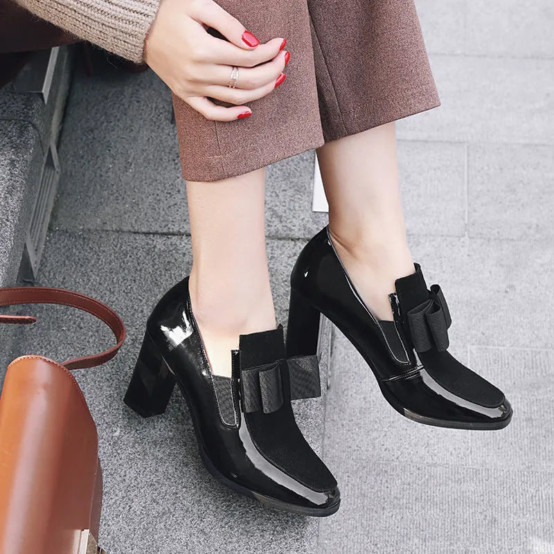 Women's black patent leather high heels with a thick square heel and square toe.