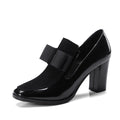 Women's black patent leather high heels with a thick square heel and square toe.