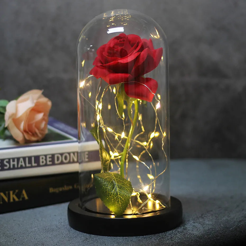 Artificial silk rose bouquet with LED string lights and glass lampshade, shown on a wooden base.