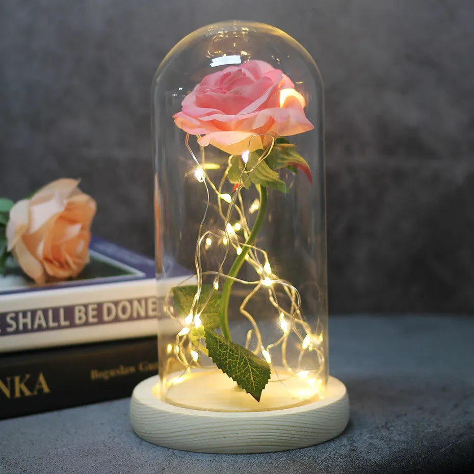 Artificial silk rose bouquet with LED string lights and glass lampshade, shown on a wooden base.