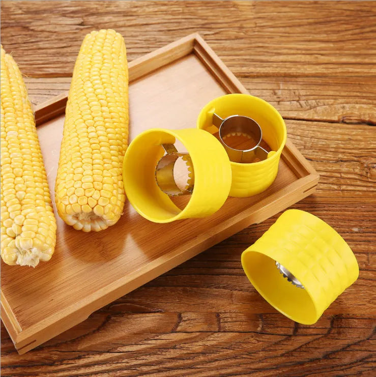 Yellow manual corn grinder thresher with corn-shaped PP handle on a kitchen counter.