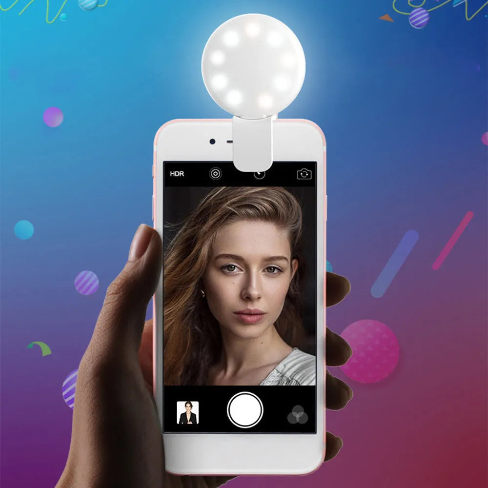 Small round clip-on LED fill light attached to a mobile phone, shown in four colour options.
