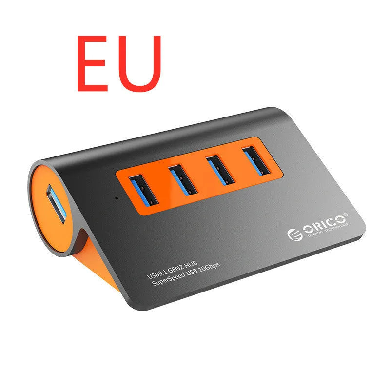 Dark grey and orange aluminium USB-C laptop docking station with four USB 3.1 ports and a separate data cable.