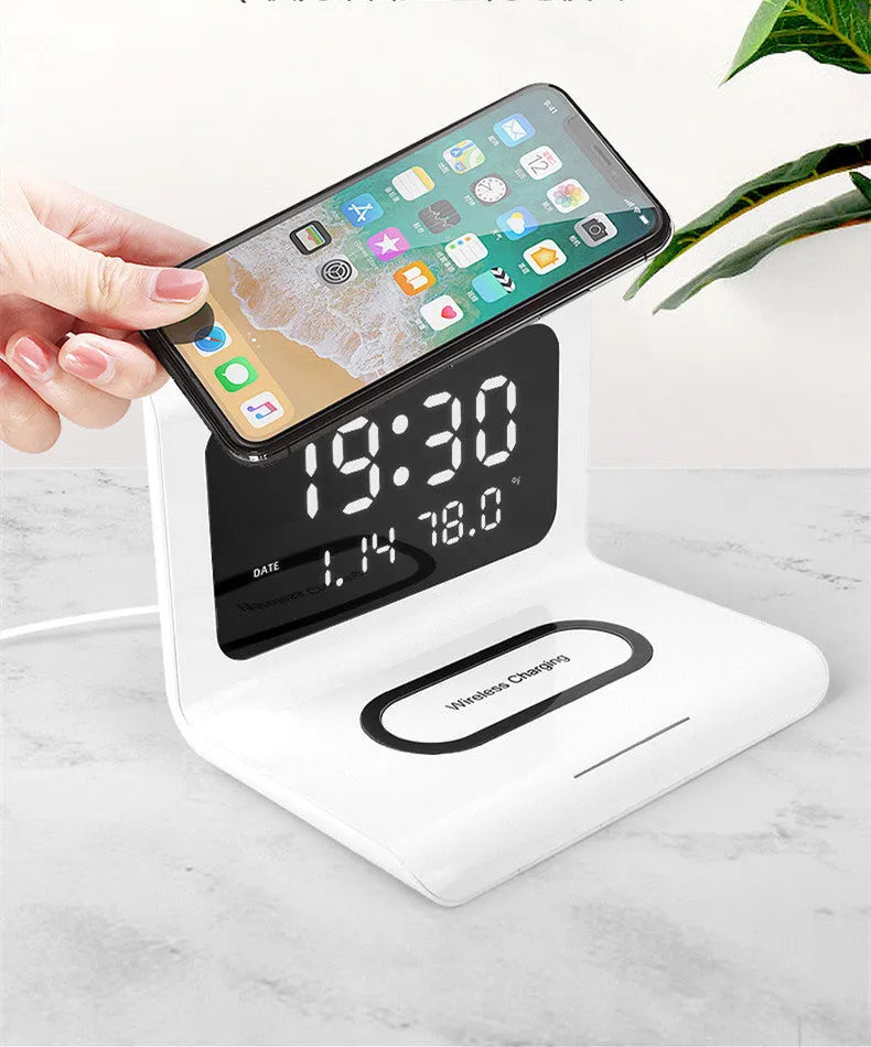 White wireless charger alarm clock displaying time, date, temperature and humidity with phone charging on pad