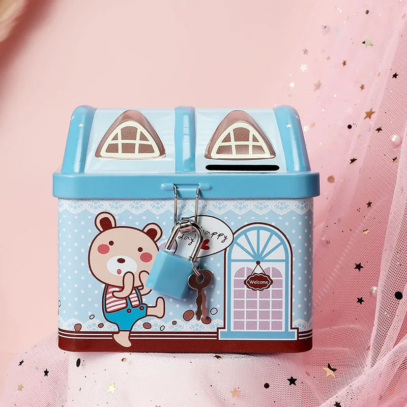 Blue house-shaped tinplate piggy bank with removable lid on wooden desk