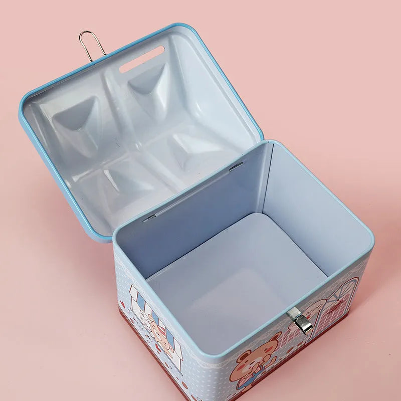 Blue house-shaped tinplate piggy bank with removable lid on wooden desk