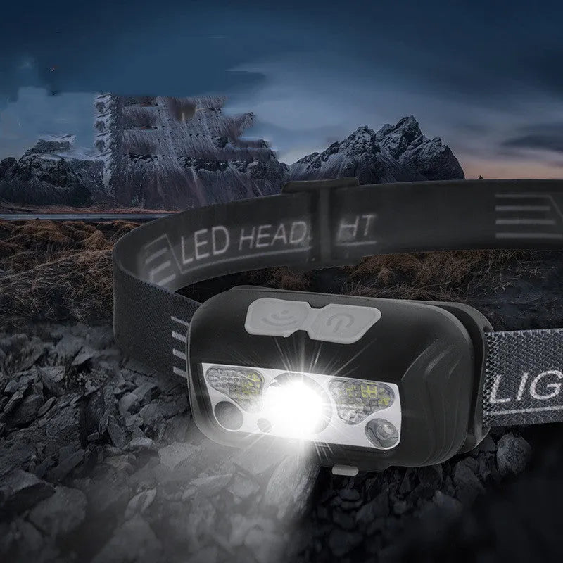 Black USB rechargeable sensor headlight showing white front LED and red rear running lights