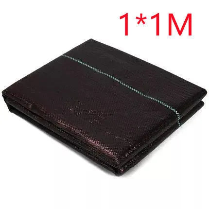 Black plastic weed-proof cloth sheet laid flat on soil for farmland and greenhouse weed suppression.