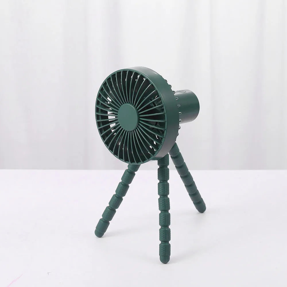 Black USB rechargeable desk fan with flexible tripod legs and an adjustable bending head on a wooden desk.