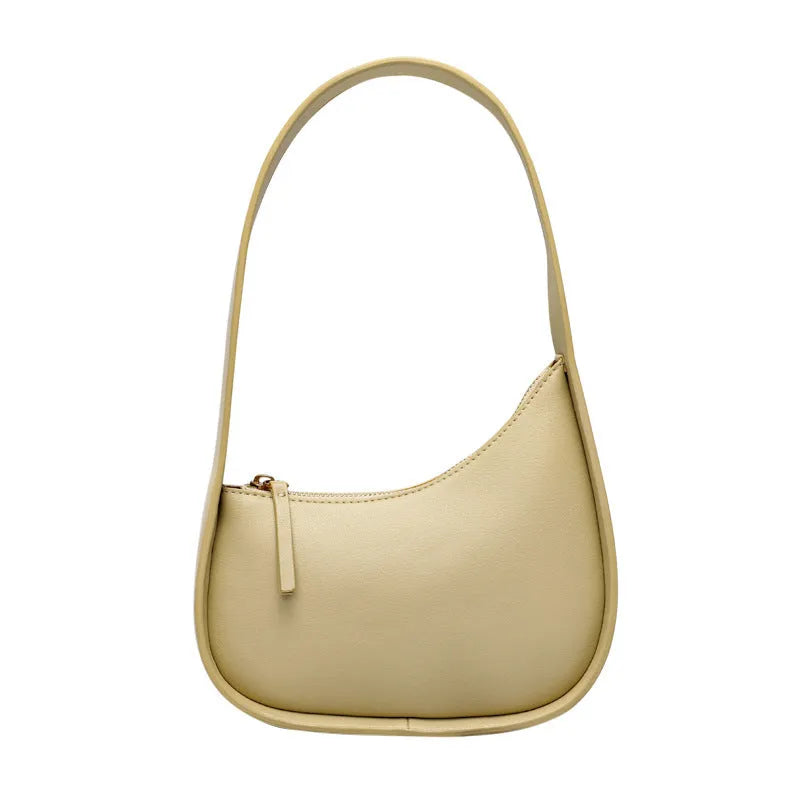Small half moon shaped women's leather shoulder bag with a wide strap and soft handle.